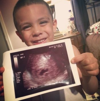 Allie's son, Aydenn, holding her new sonogram 